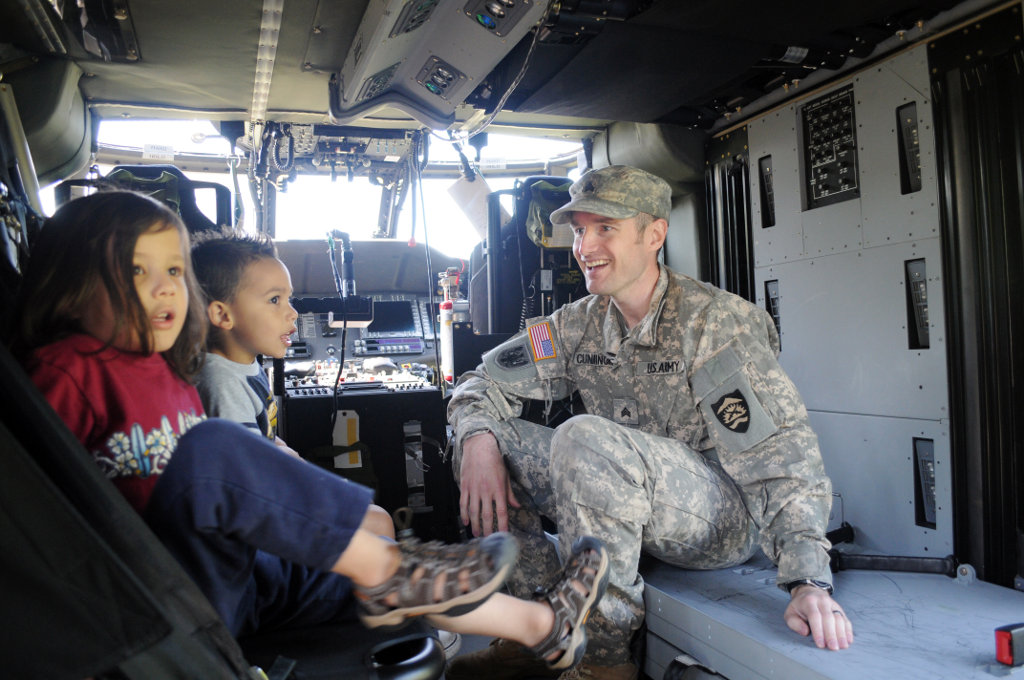 Sgt. Joseph Cunningham talks to local children inside an Oregon Army National Guard UH-60 Blackhawk helicopter Sgt. Joseph Cunningham talks to local children inside an Oregon Army National Guard UH-60 Blackhawk helicopter