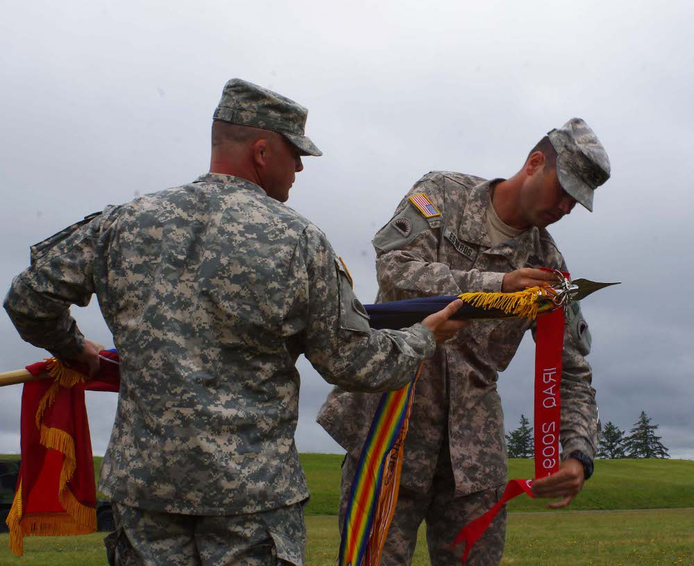Col. William Edwards, commander of the 41 Infantry Brigade Combat Team, Oregon Army National Guard, affixes a Meritorious Unit Citation streamer to the brigade's guidon during an award ceremony held at Camp Rilea, in Warrenton, Ore., July 20. The 41 IBCT was recognized for the achievements of Headquarters and Headquarters Company 41 IBCT and the 41 Special Troops Battalion during their 2009-2010 deployment to Iraq. (Photo by Master Sgt. Eric Frey, 41 Infantry Brigade Combat Team)