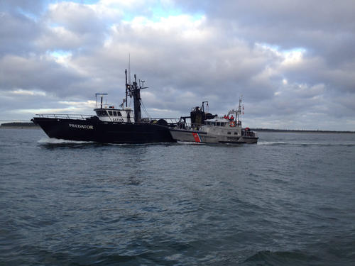 A Coast Guard 47-foot motor lifeboat crew helps propel the 180-ton, 90-foot fishing vessel Predator across the Columbia River bar, west of Astoria, Ore., Saturday, Sept. 1, 2012. The vessel lost power approximately 20 miles west of the river's entrance, Friday. U.S. Coast Guard photo by Petty Officer 1st Class Nicholas Palisano