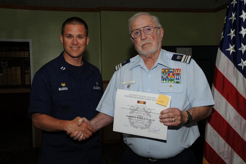 Lt. Scott McGrew (left), commanding officer at Coast Guard Station Cape Disappointment in Ilwaco, Wash., congratulates Coast Guard Auxiliary member Larry Kellis