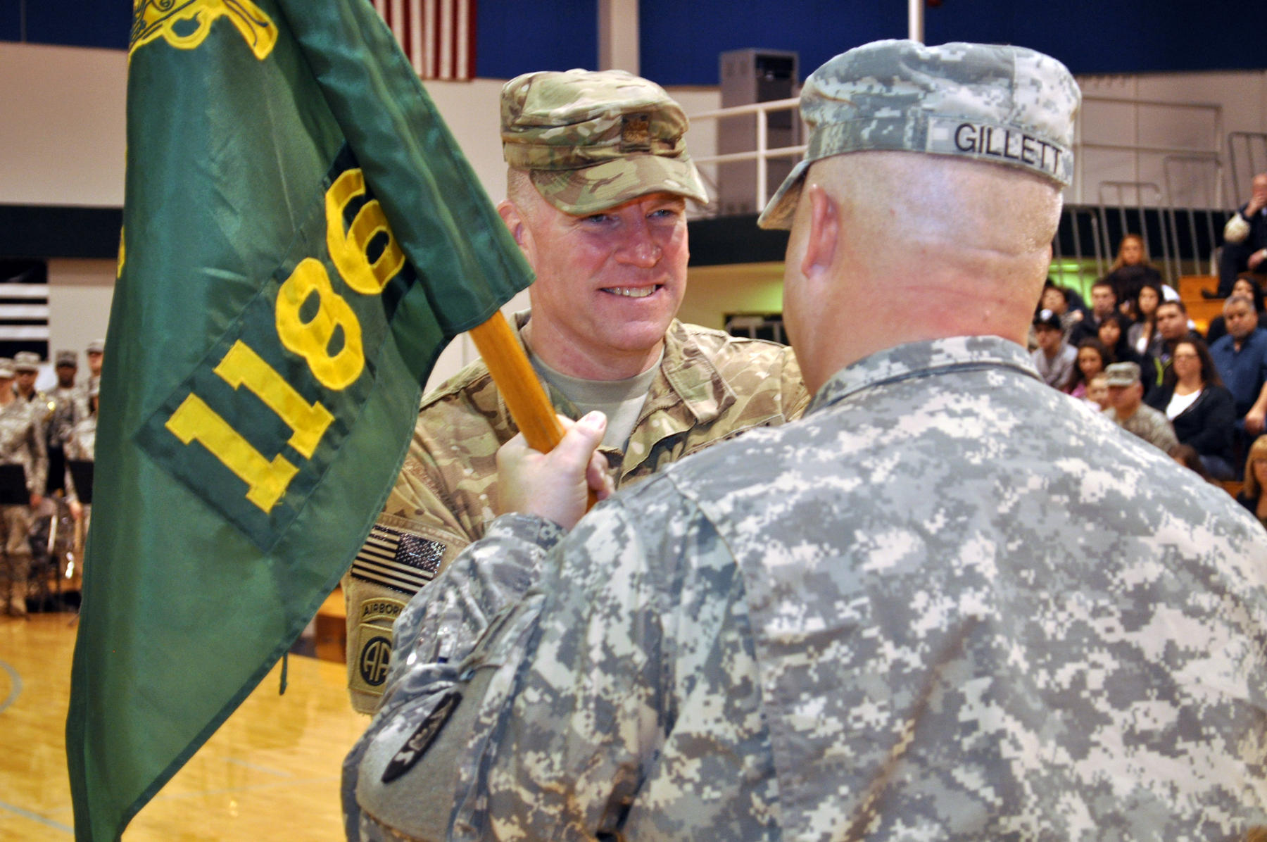 Oregon Army National Guard 1186 Military Police Company outgoing commander, Maj. William Gillentine hands the unit guidon to 821 Troop Command Battalion Commander, Lt. Col. Michael Gillett,