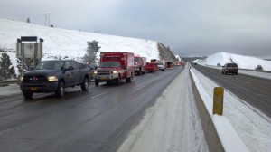 A photograph taken from the roadway showing emergency responding personnel at scene