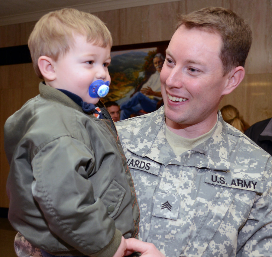 Oregon Army National Guard Sgt. Jonathan Edwards holds his son, Grant, as he talks with family, following the mobilization ceremony of his unit at the State Capitol in Salem, Ore., Feb. 21. Soldiers with Charlie Company, 7-158 Aviation, will deploy to Kosovo as a Forward Support Medical Evacuation Team (FSMT) using the UH-60 Blackhawk helicopters. (Photo by Staff Sgt. April Davis, Oregon Military Department Public Affairs)